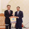 Bí thư Tỉnh ủy Lai Châu Lê Minh Ngân (bên phải) tặng sản phẩm Hồng trà của tỉnh Lai Châu cho Bí thư Tỉnh ủy Vân Nam Trung Quốc Vương Ninh. (Ảnh: Quý Trung/TTXVN)