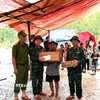 Các lực lượng chức năng thăm hỏi, động viên gia đình nạn nhân. (Ảnh: TTXVN phát)