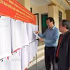 Cử tri xã Hương Sơn (Hà Tĩnh) xem thông tin niêm yết về đại biểu và danh sách cử tri. (Ảnh: Hữu Quyết/TTXVN)