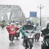 Người dân đi lại trong mưa lớn ở phía Nam cầu Trường Tiền, trung tâm thành phố Huế. (Ảnh: Nguyên Lý/TTXVN)