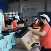 Công nhân nhà máy nhựa Đại Đồng Tiến (Thành phố Hồ Chí Minh) dán nhãn, đóng gói bao bì sản phẩm. (Ảnh: Xuân Anh/TTXVN)