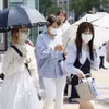 Người dân di chuyển trên đường phố dưới trời nắng nóng tại Fukuoka (Nhật Bản). (Ảnh: Kyodo/TTXVN)