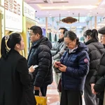 Khách hàng chờ bán đồ trang sức bằng vàng tại một máy bán vàng tự động đặt trong một trung tâm mua sắm ở Thượng Hải. (Ảnh: AFP)