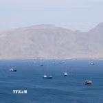 Tàu thuyền di chuyển trên eo biển Hormuz, ngoài khơi tỉnh Musandam, Oman, ngày 27/4/2026. (Ảnh: Reuters/TTXVN)