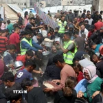 Người dân Palestine nhận thức ăn cứu trợ tại thành phố Gaza ngày 2/5/2025. (Ảnh: THX/TTXVN)