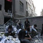 Người dân ngồi trên đống đổ nát của những tòa nhà bị phá hủy do xung đột tại Tehran, Iran ngày 15/3/2026. (Ảnh: THX/TTXVN)