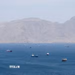 Tàu thuyền di chuyển trên eo biển Hormuz, ngoài khơi tỉnh Musandam, Oman, ngày 27/4/2026. (Ảnh: Reuters/TTXVN)
