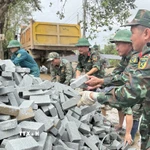 Chiến sỹ Đoàn Kinh tế-Quốc phòng 207/Quân khu 5 vận chuyển vật liệu xây sửa nhà cho người dân. (Ảnh: Tường Quân/TTXVN)