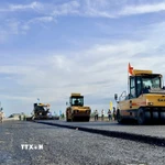 Thi công thảm bê tông nhựa trên tuyến chính cao tốc đoạn qua địa bàn phường Vĩnh Tế, tỉnh An Giang. (Ảnh: Thanh Sang/TTXVN)