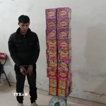 Đối tượng Hà Văn Giáp cùng số pháo hoa tang vật. (Ảnh: TTXVN phát)