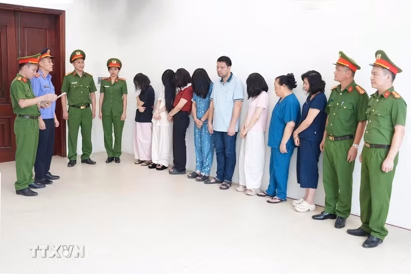 Cơ quan công an đọc lệnh khởi tố vụ án, khởi tố bị can nhóm đối tượng liên quan đến Phòng khám Đa khoa Y học Nghệ An về tội "Lừa dối khách hàng". (Ảnh: TTXVN phát)