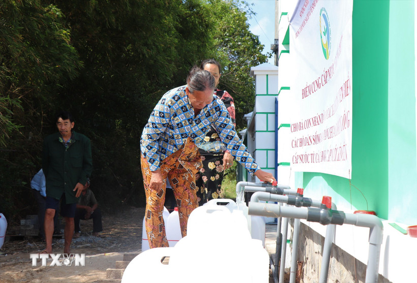 Người dân xã Vĩnh Châu nhận nước sạch miễn phí. (Ảnh: Thu Hiền/TTXVN)