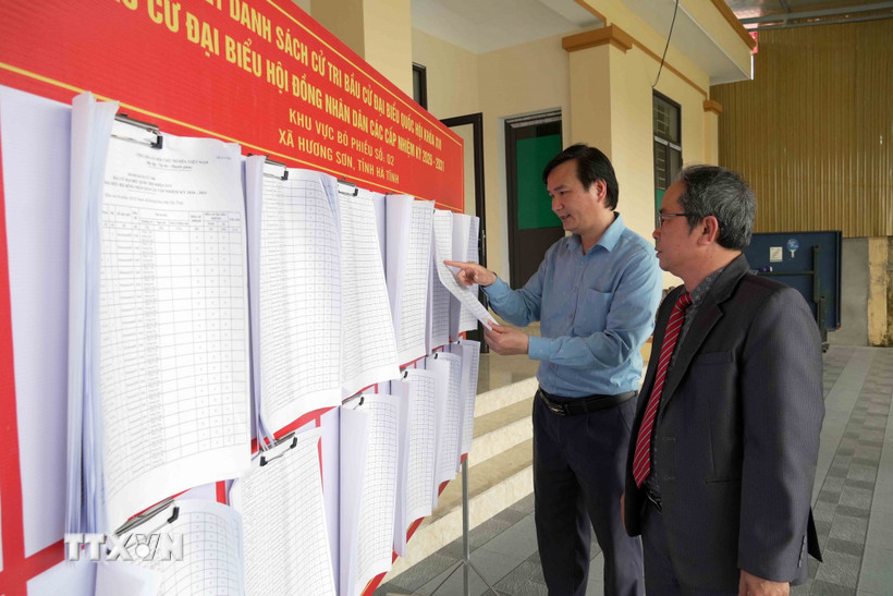 Cử tri xã Hương Sơn (Hà Tĩnh) xem thông tin niêm yết về đại biểu và danh sách cử tri. (Ảnh: Hữu Quyết/TTXVN)