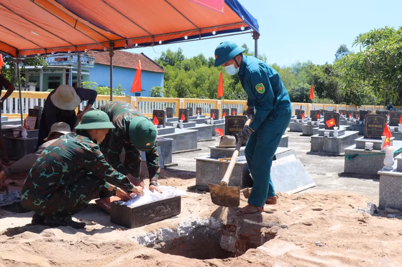Việc khai quật phần mộ lấy mẫu trong điều kiện nắng nóng gay gắt, khắc nghiệt. (Ảnh: Phạm Cường/TTXVN)