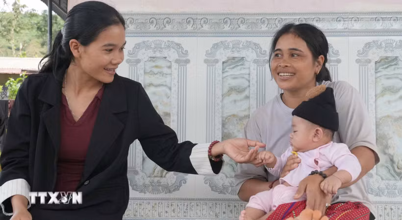 Chị Y Lạnh (sinh năm 2000, ngoài cùng bên trái), Trưởng thôn Vai Trang, xã Đăk Long thăm hỏi người dân trong thôn. (Ảnh: Dư Toán/TTXVN)