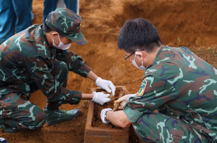 Từng công đoạn khai quật đều được thực hiện hết sức cẩn trọng, tỉ mỉ, bảo đảm giữ gìn nguyên trạng các di vật, mẫu vật và thông tin liên quan phục vụ công tác xác minh. (Ảnh: TTXVN phát)