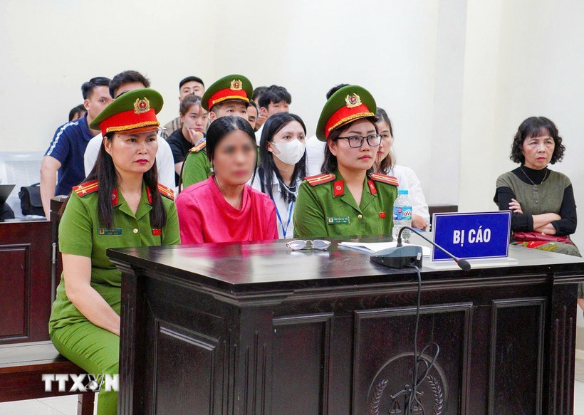Bị cáo Nguyễn Thị Bình (áo hồng, giữa) tại phiên tòa. (Ảnh: Kim Anh/TTXVN)