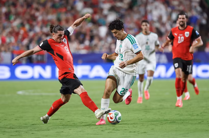 Pha tranh bóng giữa tiền vệ Algeria Ibrahim Maza (giữa) và tiền vệ Áo Marcel Sabitzer. (Ảnh: THX/TTXVN phát)