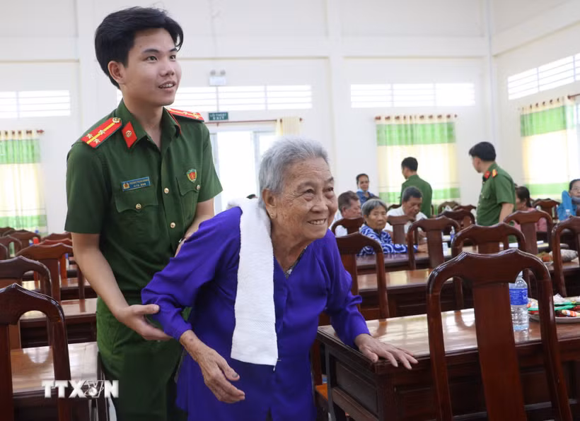 Lực lượng Công an hỗ trợ thân nhân các liệt sỹ đến lấy mẫu ADN tại Vĩnh Long. (Ảnh: Lê Thúy Hằng/TTXVN)