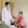 Bác sỹ Bệnh viện Chợ Rẫy Thành phố Hồ Chí Minh thăm khám, dặn dò bệnh nhân sau khi được xử lý tai biến do phẫu thuật thẩm mỹ không an toàn. (Ảnh: TTXVN phát)