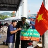 Các chiến sỹ biên phòng cùng với xe gắn máy và chiếc loa kéo mini di chuyển khắp các cảng cá, bến bãi, khu dân cư để tuyên truyền pháp luật. (Ảnh: TTXVN phát)