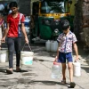 Các em nhỏ lấy nước tại điểm cấp nước công cộng ở New Delhi, Ấn Độ. (Ảnh: AFP/TTXVN)