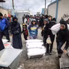 Người tị nạn Palestine nhận lương thực cứu trợ từ UNRWA ở Dải Gaza, ngày 28/1. (Ảnh: AFP/TTXVN)