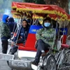 Những người đạp xe xích lô co ro trong lúc chờ khách. (Ảnh minh họa. Tuấn Anh/TTXVN)
