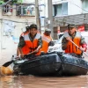 Cảnh sát Trung Quốc giúp sơ tán người dân khỏi các khu vực ngập lụt. (Ảnh: AFP/TTXVN)