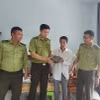 Anh Lê Nhật Hoàng bàn giao cá thể tê tê cho Hạt kiểm lâm Châu Đức-Bà Rịa. (Ảnh: Hoàng Nhị/TTXVN)