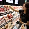 Khách hàng chọn mua son môi tại một cửa hàng. (Ảnh: Yonhap/TTXVN)