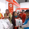 Người có hoàn cảnh khó khăn được nhận quà ở gian hàng tại “Chợ Tết nhân ái." (Ảnh: Hoàng Hùng/TTXVN)