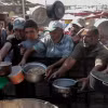 Người dân nhận thức ăn cứu trợ tại thành phố Khan Younis, Dải Gaza. (Ảnh: THX/TTXVN)
