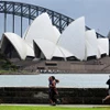Người dân tập thể dục tại khu vực Cầu cảng Sydney, bang New South Wales (Australia). (Ảnh: AFP/TTXVN)