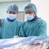 Các bác sĩ thực hiện hút huyết khối cho bệnh nhân. (Ảnh: TTXVN phát)