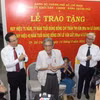 Bí thư Thành ủy Thành phố Hồ Chí Minh Nguyễn Văn Nên trao huy hiệu Đảng cho nhà thơ Lê Giang và nhạc sỹ Lư Nhất Vũ. (Ảnh: Chí Tưởng/TTXVN)