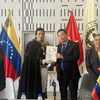 Tiến sỹ Juan Gamez trao tặng ảnh Chủ tịch Hồ Chí Minh do chính ông vẽ cho Đại sứ Việt Nam tại Venezuela Vũ Trung Mỹ. (Ảnh: TTXVN phát)