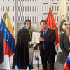 Tiến sỹ Juan Gamez trao tặng ảnh Chủ tịch Hồ Chí Minh do chính ông vẽ cho Đại sứ Việt Nam tại Venezuela Vũ Trung Mỹ. (Ảnh: TTXVN phát)