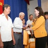 Quyền Chủ tịch nước Võ Thị Ánh Xuân tặng quà cho các hộ gia đình. (Ảnh: Giang Phương/TTXVN)
