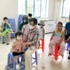 Người dân phường An Lạc, quận Bình Tân đưa trẻ đến trạm y tế phường tiêm vaccine phòng sởi. (Ảnh: Đinh Hằng/TTXVN)