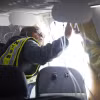 Điều tra viên kiểm tra phần cửa sổ bị bung ra của máy bay Boeing 737 MAX 9 thuộc hãng hàng không Alaska Airlines. (Ảnh: AFP/TTXVN)
