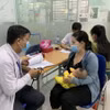 Phụ huynh đưa trẻ đi tiêm vaccine phòng bệnh sởi. (Ảnh: Đinh Hằng/TTXVN)