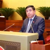 Bộ trưởng Bộ Kế hoạch và Đầu tư Nguyễn Chí Dũng trình bày Báo cáo Đánh giá giữa Nhiệm kỳ Thực hiện Kế hoạch Phát triển Kinh tế - Xã hội 5 năm 2021-2025 và Kế hoạch Cơ cấu lại nền Kinh tế giai đoạn 2021-2025. (Ảnh: Phạm Kiên/TTXVN)