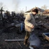 Người dân Ukraine thu dọn đống đổ nát của một ngôi nhà bị phá hủy sau vụ cháy nổ. (Nguồn: AFP/TTXVN)