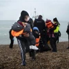 Người di cư được đưa về bãi biển ở Dungeness, phía Đông Nam vùng England, sau khi được giải cứu ở eo biển Channel. (Ảnh: AFP/TTXVN)