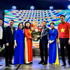Ông Chu Tuấn Đức, Tham tán Công sứ Đại sứ quán Việt Nam tại Đức, tặng hoa cho bà Bùi Thị Thu Minh, tân Trưởng Ban liên lạc người Việt châu Âu “Vì biển đảo Việt Nam”. (Ảnh: Thu Hằng/TTXVN)