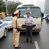Một trường hợp xe khách đón trả khách sai quy định, đi với tốc độ kiểu “rùa bò” bị lực lượng Phòng Cảnh sát Giao thông, Công an thành phố Hà Nội, dừng xe, kiểm tra và lập biên bản. (Ảnh: Phạm Kiên/TTXVN)
