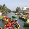 Du khách ngồi trên các chiếc thuyền thúng do người dân địa phương chèo để tận hưởng vẻ đẹp sông nước. (Ảnh: Thúy Lan/Vietnam+)