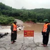 Lực lượng Đồn Biên phòng Ra Mai, huyện Minh Hóa, chốt chặn không cho người dân qua các ngầm tràn khi nước lũ dâng cao. (Ảnh: TTXVN phát)
