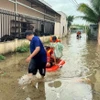 Cán bộ, chiến sỹ Ban Chỉ huy Quân sự thành phố Phú Quốc, tỉnh Kiên Giang, cùng với lực lượng địa phương ứng cứu, sơ tán người dân đến nơi an toàn do mưa lớn gây ngập cục bộ trên đảo. (Ảnh: TTXVN phát)